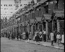 People Out the Front of Their Houses in a Street Decorated With Union Flag Bunting in Belfast, 1921. Creator: British Pathe Ltd