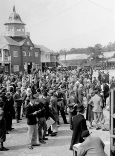 People attending a motor racing event at Brooklands. Artist: Bill Brunell