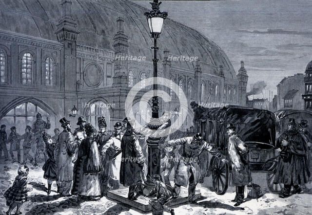 People around a new electrical lamppost in the train station of Friedrichstandt, engraving from 1…