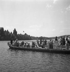 People arrive in long boats, called church boats, for the Midsummer celebrations, Sweden, 1941. Artist: Torkel Lindeberg