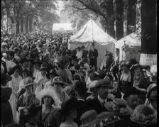 People Gathering and Relaxing at a Fairground Between Marquees and Balloons, 1920. Creator: British Pathe Ltd