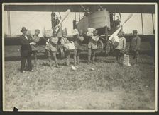 People loading supplies on airplane, 1919-1930. Creator: Fédèle Azari