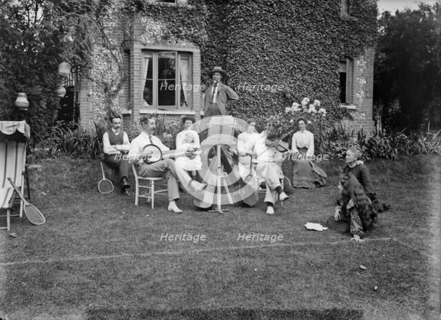 People playing music in a garden, c1896-c1920. Artist: Alfred Newton & Sons