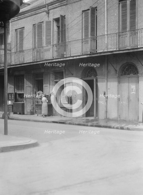 People standing by the doorway of a furniture shop in the French Quarter, New Orleans, c1920-1926. Creator: Arnold Genthe.