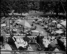 People Sitting at Tables on a Balcony While Another Group of People Sit Below, 1933. Creator: British Pathe Ltd