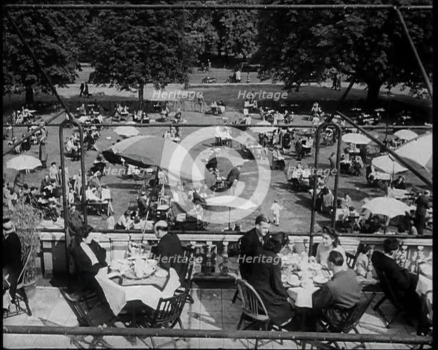People Sitting at Tables on a Balcony While Another Group of People Sit Below, 1933. Creator: British Pathe Ltd.