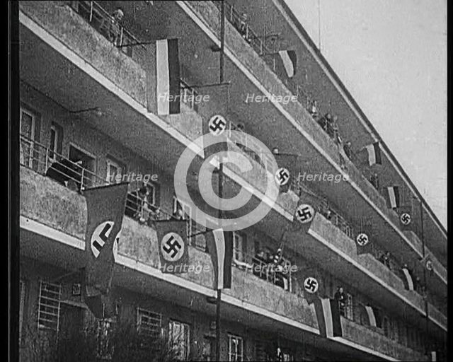 People Waving Flags of the Nazi Party and German Flags of 1867–1918 from Balconies, 1933. Creator: British Pathe Ltd.