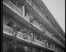 People Waving Flags of the Nazi Party and German Flags of 1867–1918 from Balconies, 1933. Creator: British Pathe Ltd