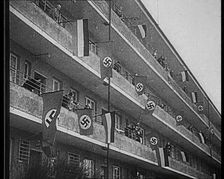 People Waving Flags of the Nazi Party and German Flags of 1867–1918 from Balconies, 1933. Creator: British Pathe Ltd