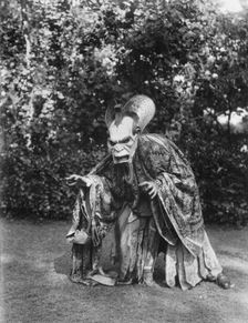 Person wearing a mask made by W.T. Benda, 1925 Sept. 20. Creator: Arnold Genthe