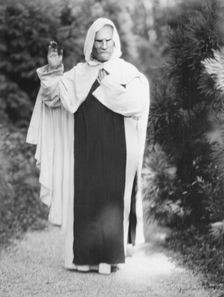 Person wearing a mask made by W.T. Benda, 1925 Sept. 20. Creator: Arnold Genthe