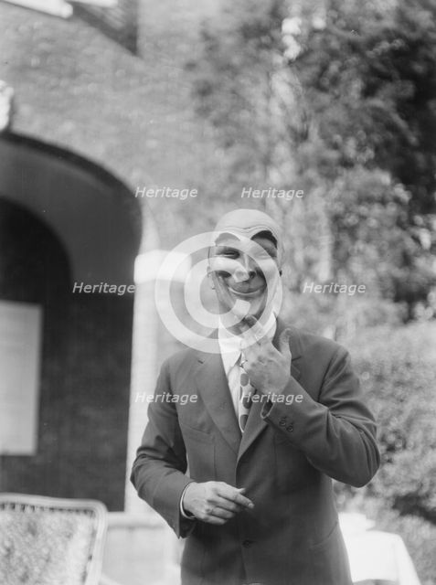 Person wearing a mask made by W.T. Benda, 1925 Sept. 20. Creator: Arnold Genthe.