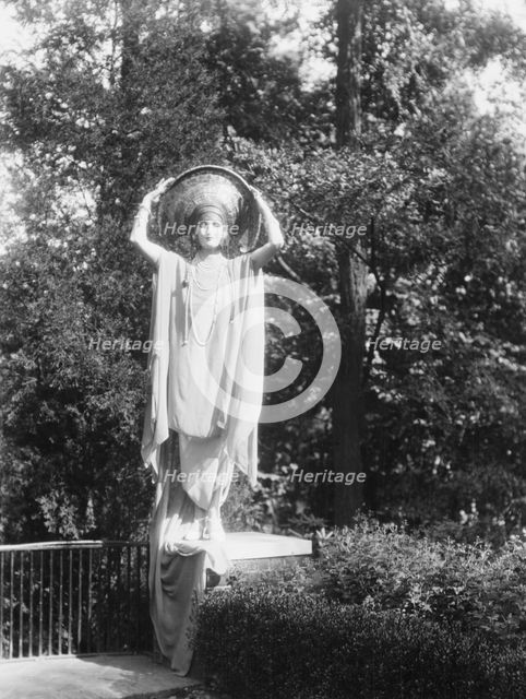 Person wearing a mask made by W.T. Benda, 1925 Sept. 20. Creator: Arnold Genthe.