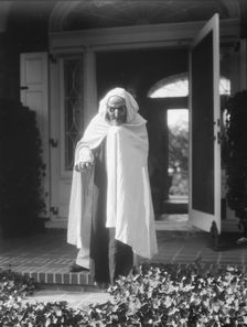 Person wearing a mask made by W.T. Benda, 1925 Sept. 20. Creator: Arnold Genthe