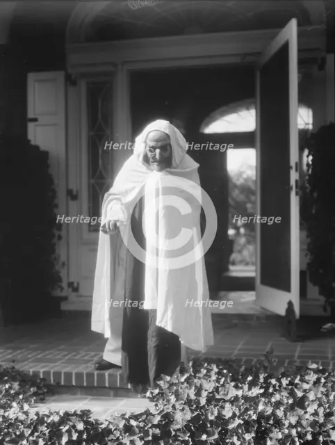 Person wearing a mask made by W.T. Benda, 1925 Sept. 20. Creator: Arnold Genthe.