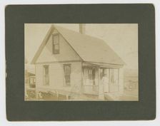 Photograph of a woman standing on the porch of a house, early 20th century. Creator: Unknown