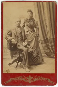 Photograph of African-American man and woman in formal clothes, late 19th century. Creator: Louis Janousek