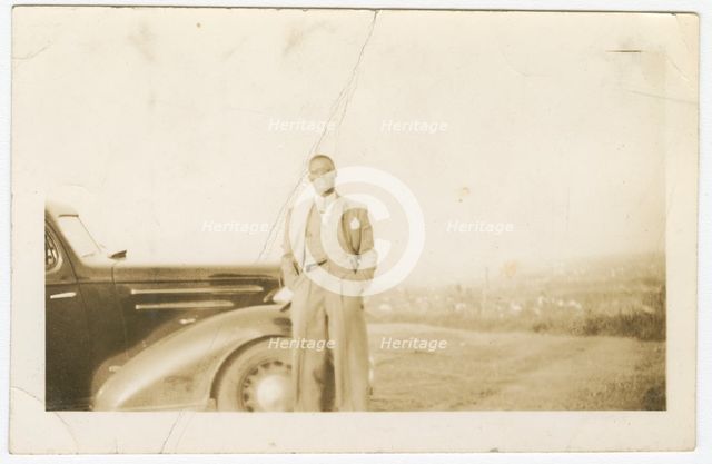Photograph of an unidentified man in front of car, ca. 1920. Creator: Unknown.