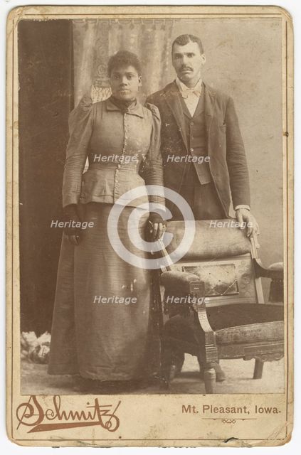 Photograph of an African-American couple standing behind a chair, ca. 1890. Creator: Schmitz Studio.