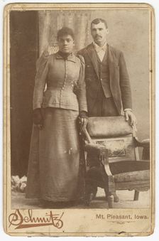 Photograph of an African-American couple standing behind a chair, ca. 1890. Creator: Schmitz Studio