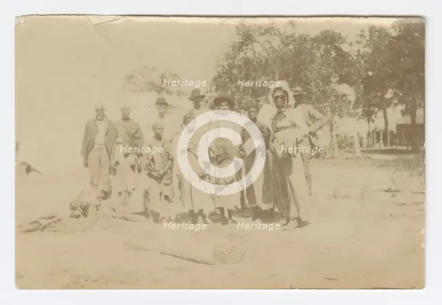 Photograph of men, women, and children in a yard, early 20th century. Creator: Unknown.