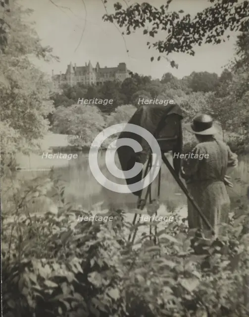 Photographer Frances Benjamin Johnston standing beside her large view camera looking..., c1938. Creator: Unknown.