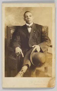 Photographic postcard of a seated man holding a bowler hat, 1904-1918. Creator: Unknown