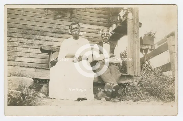 Photographic postcard of an elderly couple sitting on a porch, 1904-1929. Creator: Unknown.