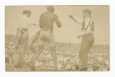 Photographic postcard of James J. Jeffries staggering away from Jack Johnson, 1910. Creator: Unknown