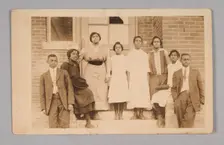 Photographic print of 8 people in front of a building, 1904-1918. Creator: Unknown