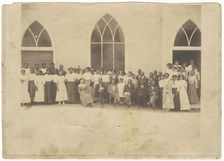 Photographic print of men and women in front of Vernon AME Church, Tulsa, ca. 1919. Creator: Unknown