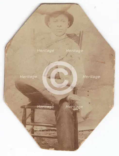 Photographic print of a man in suit sitting on a chair with right leg crossed, late 19th-early 20th  Creator: Unknown.