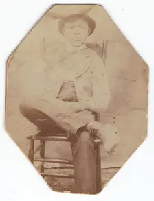 Photographic print of a man in suit sitting on a chair with right leg crossed, late 19th-early 20th Creator: Unknown