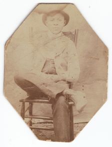 Photographic print of a man in suit sitting on a chair with right leg crossed, late 19th-early 20th Creator: Unknown