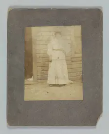 Photographic print of a woman in front of a building, late 19th century. Creator: Unknown