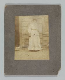 Photographic print of a woman in front of a building, late 19th century. Creator: Unknown