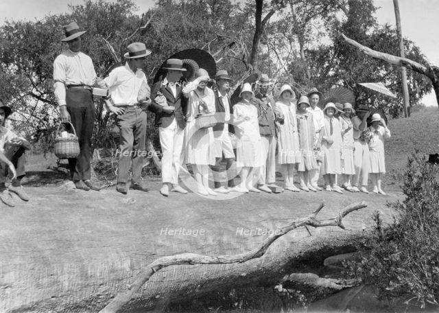 Picnic party on a log over Cressbrook Creek, 1925. Creator: Jack Bain.