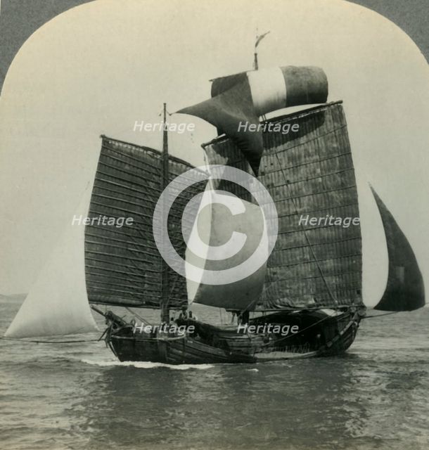 'Picturesque Chinese Junk under Full Sail on the Yellow Sea, Coast of Manchukuo in Distance', c1930s Creator: Unknown.