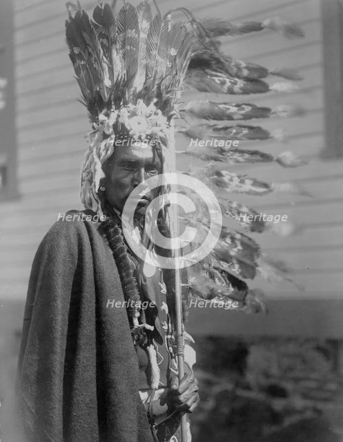 Piegan war-bonnet and coup-stick, c1910. Creator: Edward Sheriff Curtis.