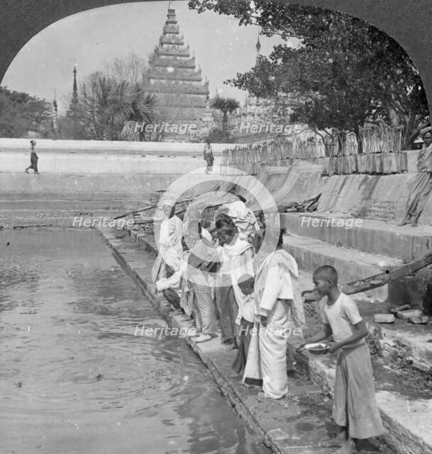 Pilgrims feeding holy turtles, Arakan Pagoda, Mandalay, Burma, 1908.  Artist: Stereo Travel Co