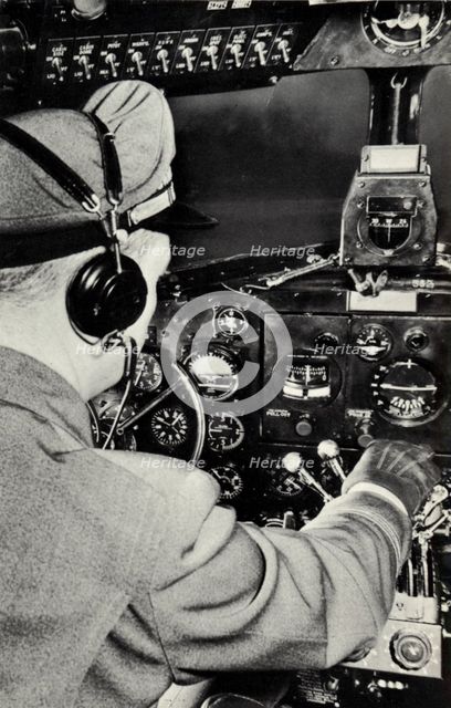 Pilot in the cockpit of a Douglas DC-3 aeroplane, 1940. Artist: Unknown
