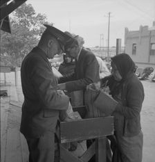 Plant quarantine inspectors examining goods bought... before entering El Paso, Texas, 1937. Creator: Dorothea Lange