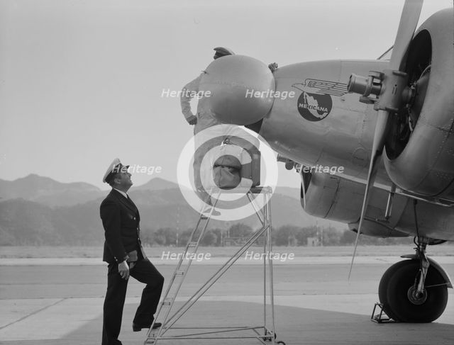 Plant quarantine inspectors examining plane at the Glendale Airport, California, 1937. Creator: Dorothea Lange.
