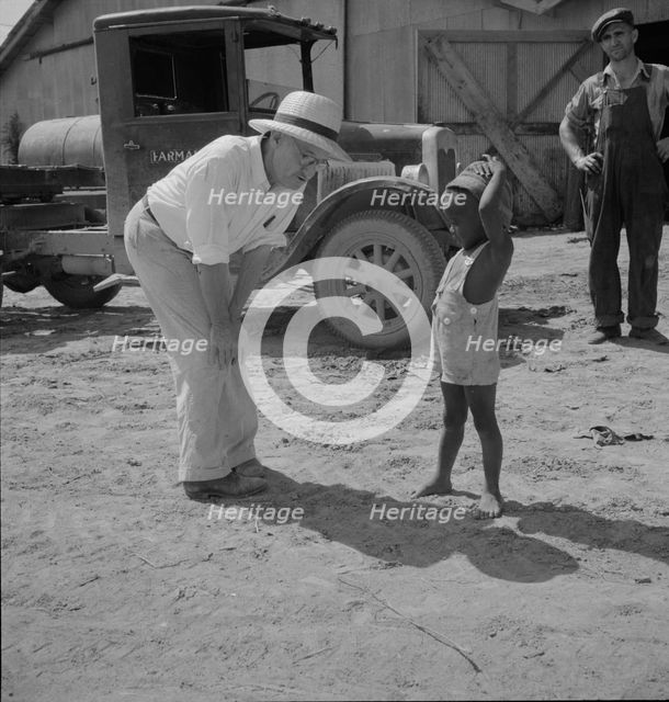 Plantation owner with one of the Negro plantation children, Aldridge Plantation, Mississippi, 1937. Creator: Dorothea Lange.