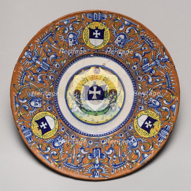 Plate with border of grotesques on an orange ground and three shields..., probably c1510/1525. Creator: Unknown.