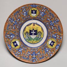 Plate with border of grotesques on an orange ground and three shields..., probably c1510/1525. Creator: Unknown