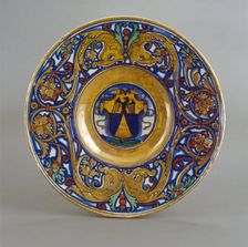 Plate with border of foliate scrollwork with dolphin heads and cornucopias; in the center..., 1524. Creator: Giorgio Andreoli workshop