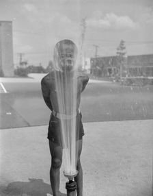 Playing in the community sprayer, Frederick Douglass housing project, Anacostia, D.C., 1942. Creator: Gordon Parks