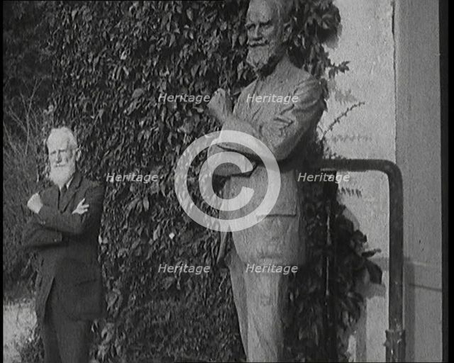 Playwright George Bernard Shaw Standing Next To a Statue of Himself, 1920s. Creator: British Pathe Ltd.