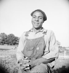Plough boy sitting on fence after a day's work, Eutaw, Alabama, 1936. Creator: Dorothea Lange